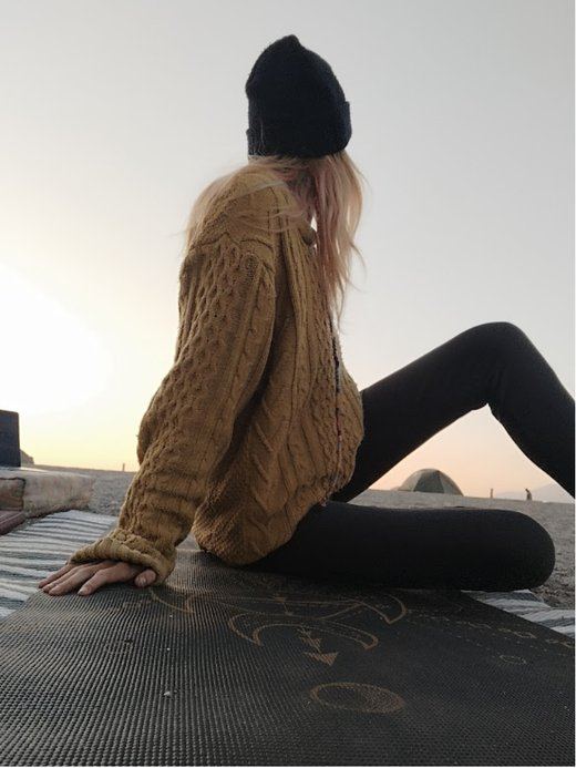 A person sitting on a beach at dusk